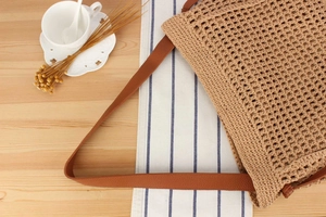 Detailed texture of handmade hollow cotton rope woven bag with premium leather straps