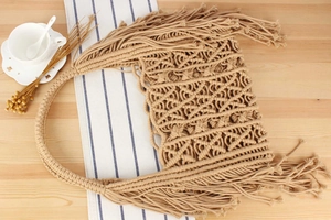 Detail of bohemian handmade woven bag featuring intricate macrame patterns and long fringes