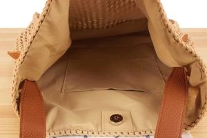 Detailed view of the woven handbag interior with fabric lining and magnetic closure