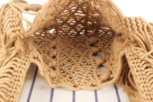 Top macro view of handmade woven bag with tassels and interior mesh structure