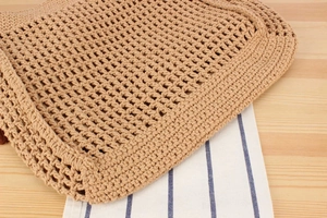 Detailed view of the handmade woven texture and hollow pattern of the cotton rope bag