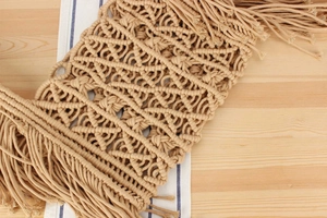 Close-up of handmade bohemian woven cotton runner with geometric patterns and fringe