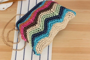 Detailed close-up of rainbow zigzag woven texture with a sleek gold metal chain strap
