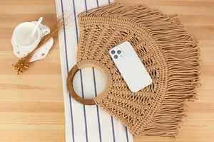 Detailed size reference of handmade macrame bag with wood handles and fringe accents