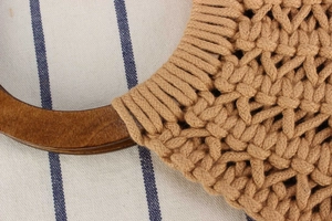Detail of hand-woven cotton rope bag showing intricate texture and round wooden handle