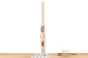 Close-up of handmade crochet tote bag with colorful flower patterns on a wooden table
