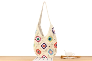 Close-up of rainbow crochet granny square shoulder bag with soft cotton texture
