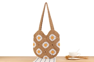 Detailaufnahme der handgefertigten Häkel-Tasche mit Gänseblümchen und Baumwollgurt