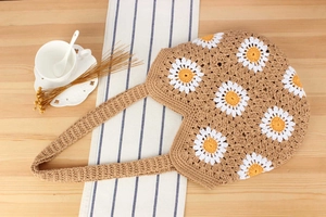 Detailaufnahme der Häkel-Gänseblümchen an der khakifarbenen Baumwollseil-Schultertasche