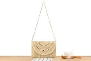 Detailed close-up of a woven crochet chain bag with radial pattern on light wood surface