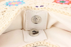 Detail of magnetic silver closure and woven lining on colorful crochet handmade bag