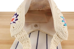 Detail of handmade crochet bag showing fabric lining, internal pocket, and magnetic closure