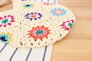 Detail of colorful crochet flower patterns and textured weave on a summer beach bag