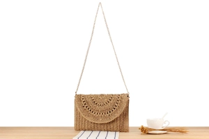 Detail of hand-woven crochet crossbody bag with wavy texture and gold chain strap