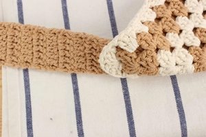 Détail de sac en coton crocheté à la main gros plan montrant une texture tricotée bicolore.