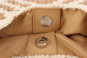Vue détaillée de la fermeture aimantée et de la doublure intérieure d'un sac tissé tendance.