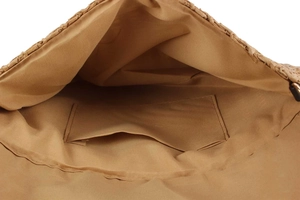 Detail view of woven straw bag interior with light brown lining and internal pocket