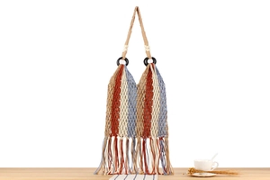 Detail of bohemian hand-woven tote bag with colorful fringe and decorative beads