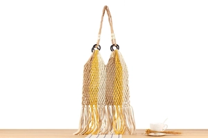 Detailed view of handmade woven tassel shoulder bag with bohemian striped cotton rope pattern