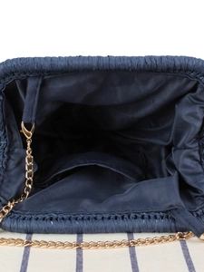 Top view of dark blue woven straw handbag with gold chain strap and inner pocket