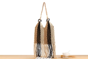 Detail of hand-woven fringe bag showing mesh pattern and decorative wooden beads