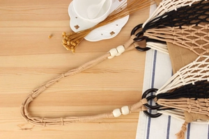 Detail of handmade woven tote bag with fringe, cotton rope handles and decorative beads
