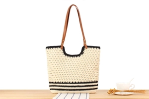 Detail of hand-woven beige tote with black stripes and brown leather shoulder straps