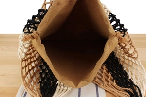 Detailed top view of handmade woven tassel bag with canvas lining and bohemian pattern