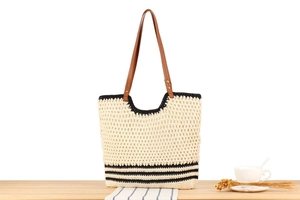 Detail of hand-woven crochet tote with contrast black stripes and brown leather straps