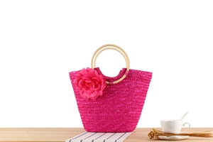 Sac en paille tressée rose avec anses rondes en bois et grand accent floral détaillé