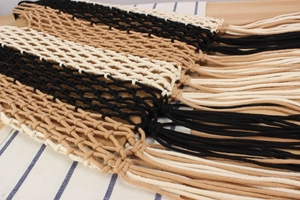 Close-up of tricolor handmade woven bag featuring mesh hollow pattern and long fringe tassels