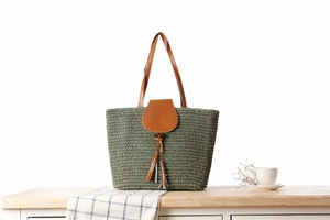 Detailed macro view of army green woven texture with brown leather strap and tassel detail