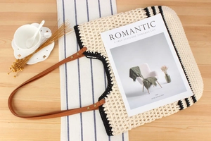 Flat lay of a woven crochet tote bag with brown leather handles and a coffee cup