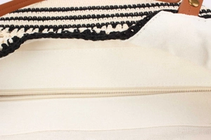 Detail of woven bag featuring wave pattern, canvas lining, and smooth zipper closure