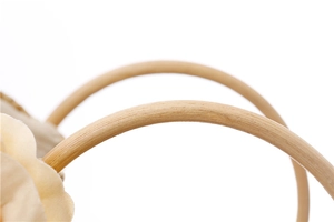 Détail macro d'une poignée ronde en bois naturel avec texture de sac en paille tressée