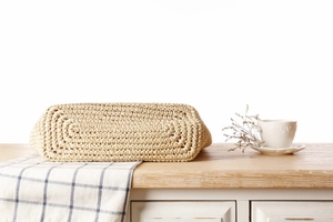 Detailed macro view of the spiral woven bottom on a beige paper rope shoulder bag