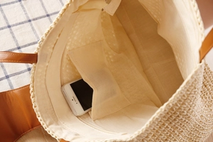 Detail view of woven paper rope tote bag interior with lining and phone pocket