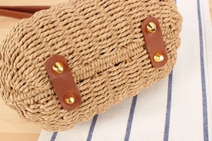 Détail du fond d'un sac en paille tissée avec renforts en cuir et picots de protection