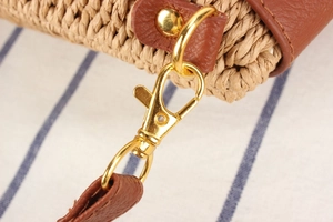 Détail d'un sac en paille tressé main avec bandoulière en cuir et fermoir doré brillant