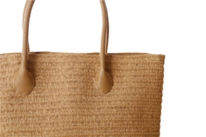 Detail of paper rope woven tote with reinforced faux leather handles and stitching