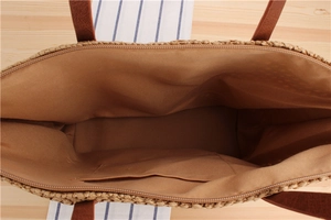 Detailed interior of woven straw tote bag featuring smooth fabric lining and pocket