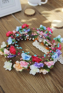 Macro shot of bohemian flower crowns with colorful petals and vine textures on wood