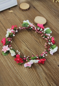 Detail of floral bridal wreath with pink and white fabric flowers on rustic wood