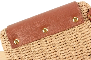 Détail du sac tissé en corde de papier avec rabat en cuir brun et rivets dorés