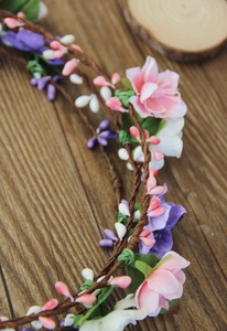 Detailed view of pink and purple silk flowers on a brown vine floral headband