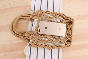 Detail of hand-woven beige tote bag with inner drawstring pouch on wooden surface