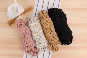 Detail of four handmade cotton rope woven bags in pink, white, khaki, and black colors