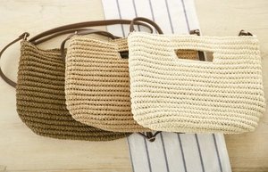 Detailed straw woven bags in brown and khaki with sleek leather shoulder straps