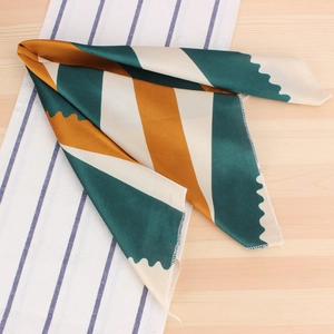 Détail d'un foulard carré en satin avec patchwork géométrique et bords ondulés