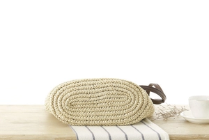Close-up of bottom oval shape of paper rope woven bag on a wooden table with home decor